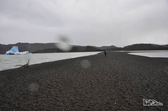 Debaixo de chuva, caminhando em praia do lago Grey, no parque Nacional Torres del Paine, no sul do Chile